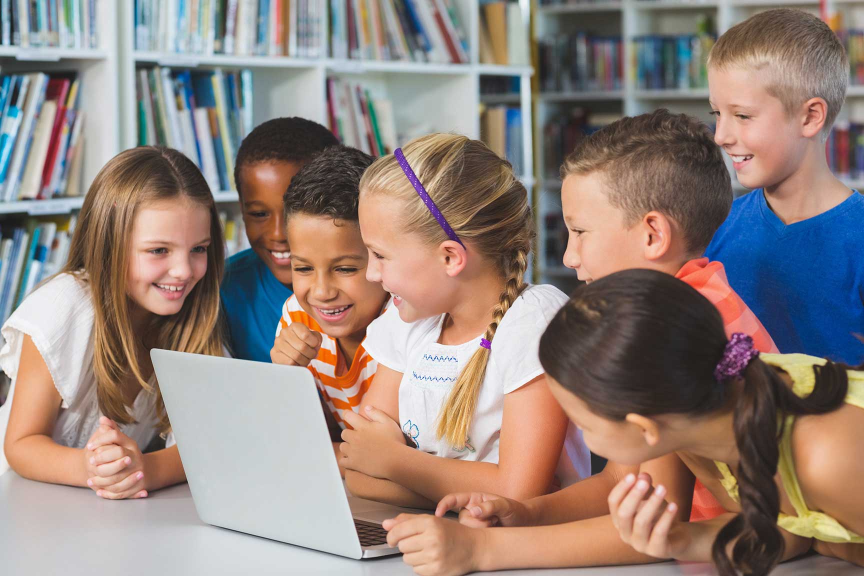 school-kids-using-laptop-in-library